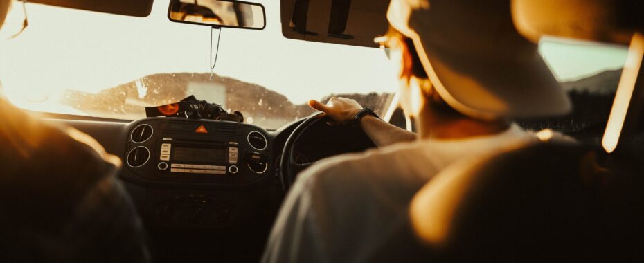 Person driving in their car at sunset.