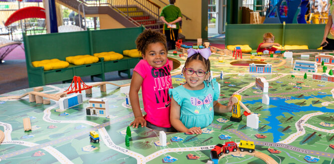 Two children play with model city set at Children's Museum.
