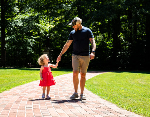 Father and daughter go for a stroll in a park in the Carolina Core