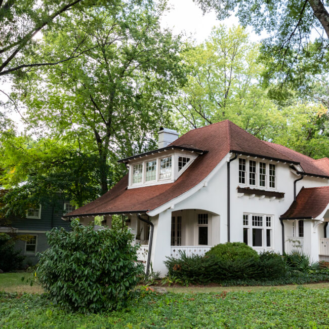 1900s white house nestled in lush green yard