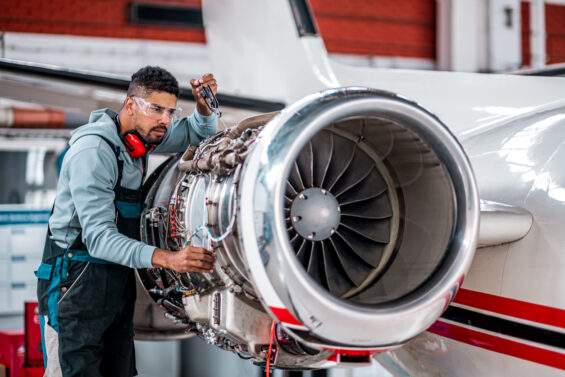 An aircraft mechanic checks on an engine