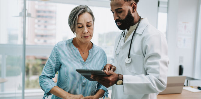 Doctor reviewing medical results on a tablet to a patient